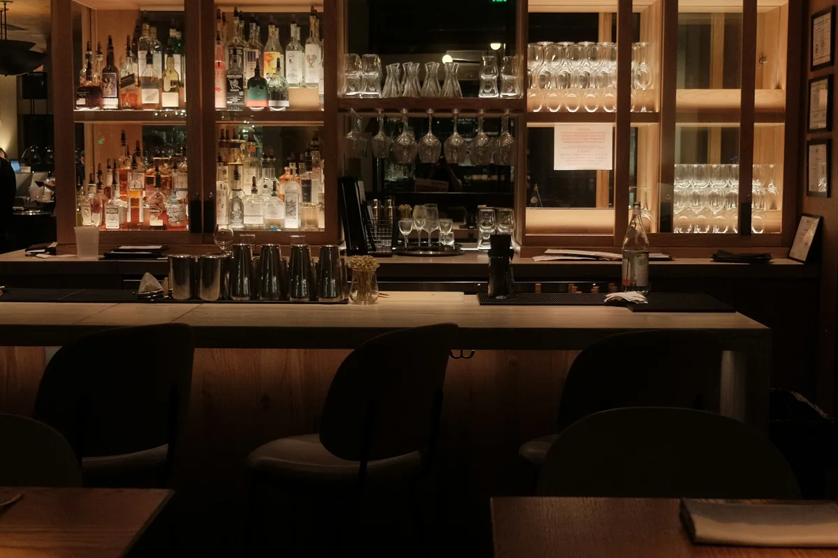 Sample photo: a dim bar counter with shelves behind it
