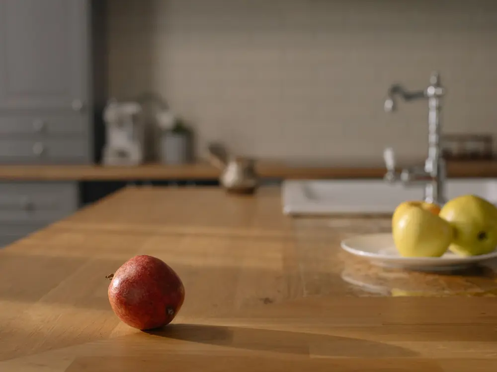 A kitchen with a wooden worktop and fruit.